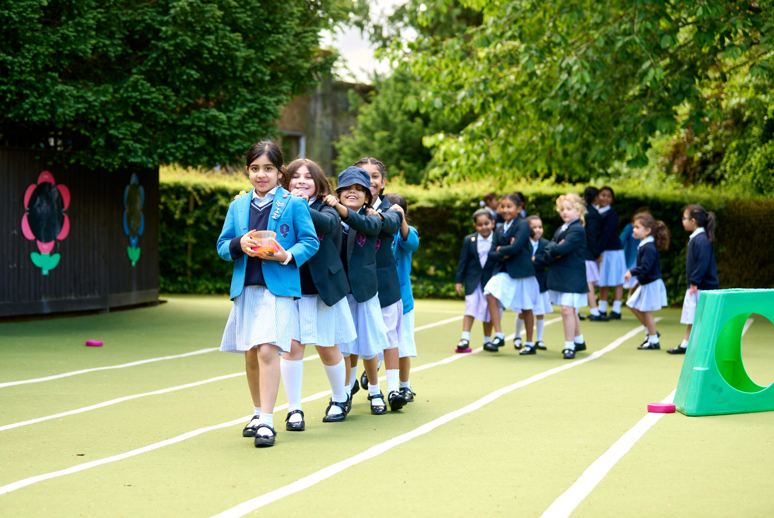 group of girls playing outside on a sports track