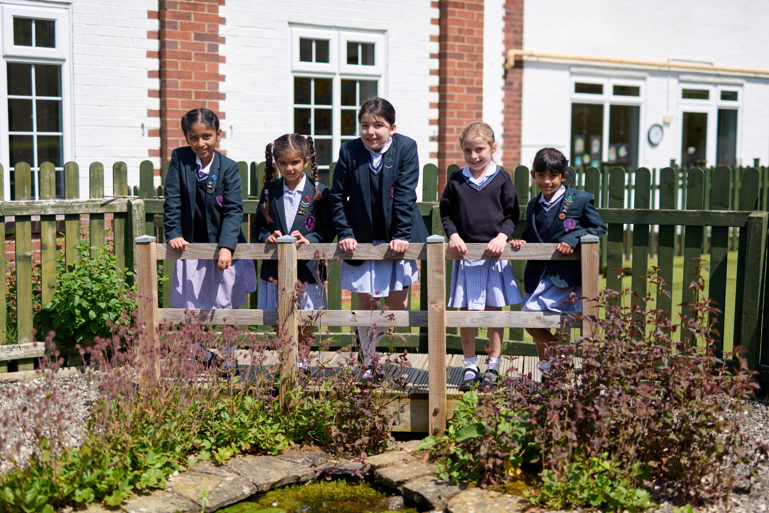 five students on a bridge outside