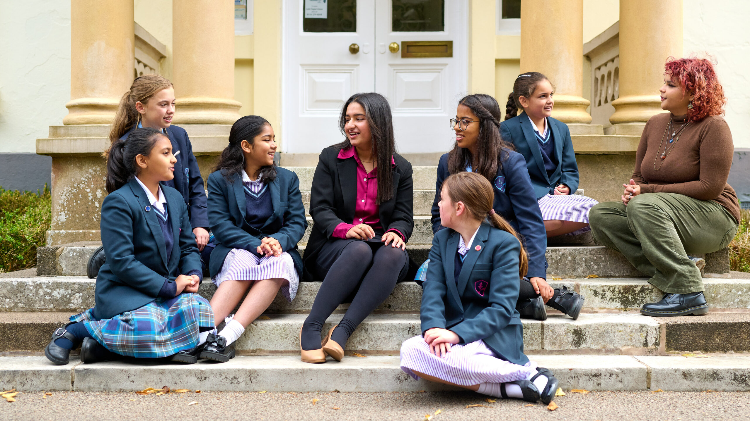 a group of girls sat on some steps